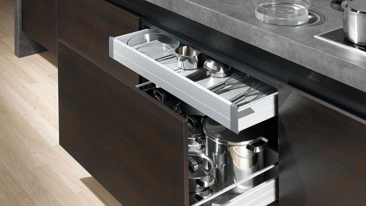 Detailaufnahme von Küchenschubladen mit viel Stauraum in dunklem Holz