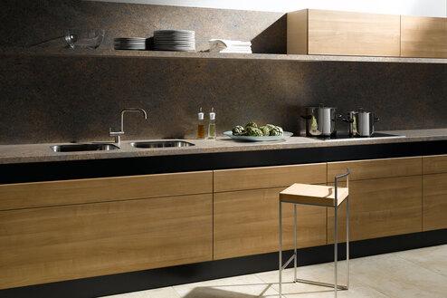 Küchenzeile aus Massivholz mit schwarzer Arbeitsplatte, Spülbecken und Wandregal