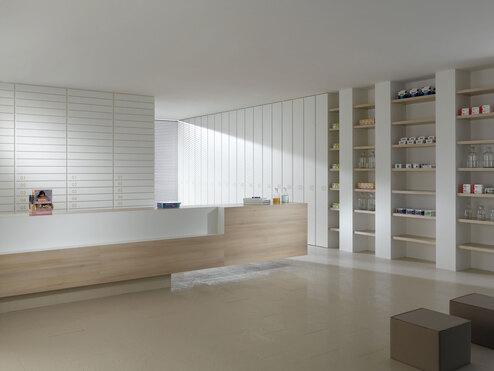 Impressionen einer Apothekeneinrichtung mit hellen Holzmöbeln und geräumigem Regalsystem, sowie aufgeräumten Empfang.