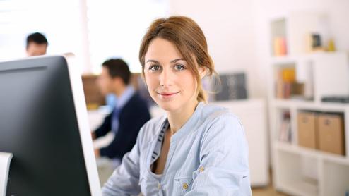 Mitarbeiterin am Schreibtisch Mitarbeiterin am Schreibtisch